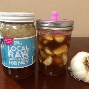 jar of fermented honey garlic with jar of local raw honey