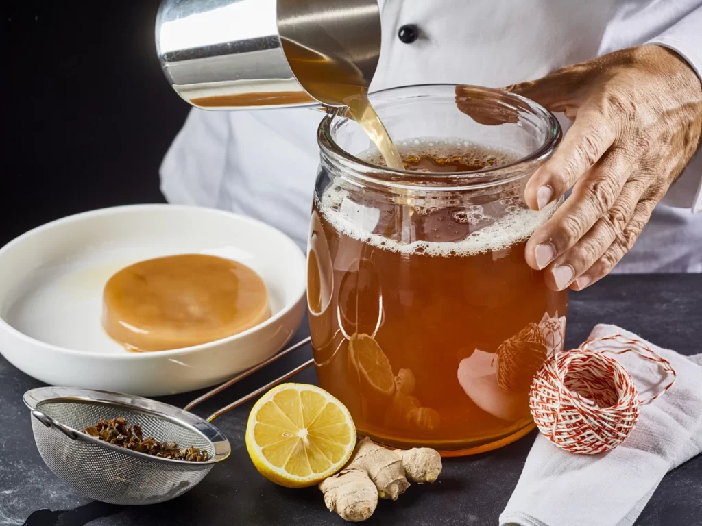 kombucha recipe pouring tea into crock