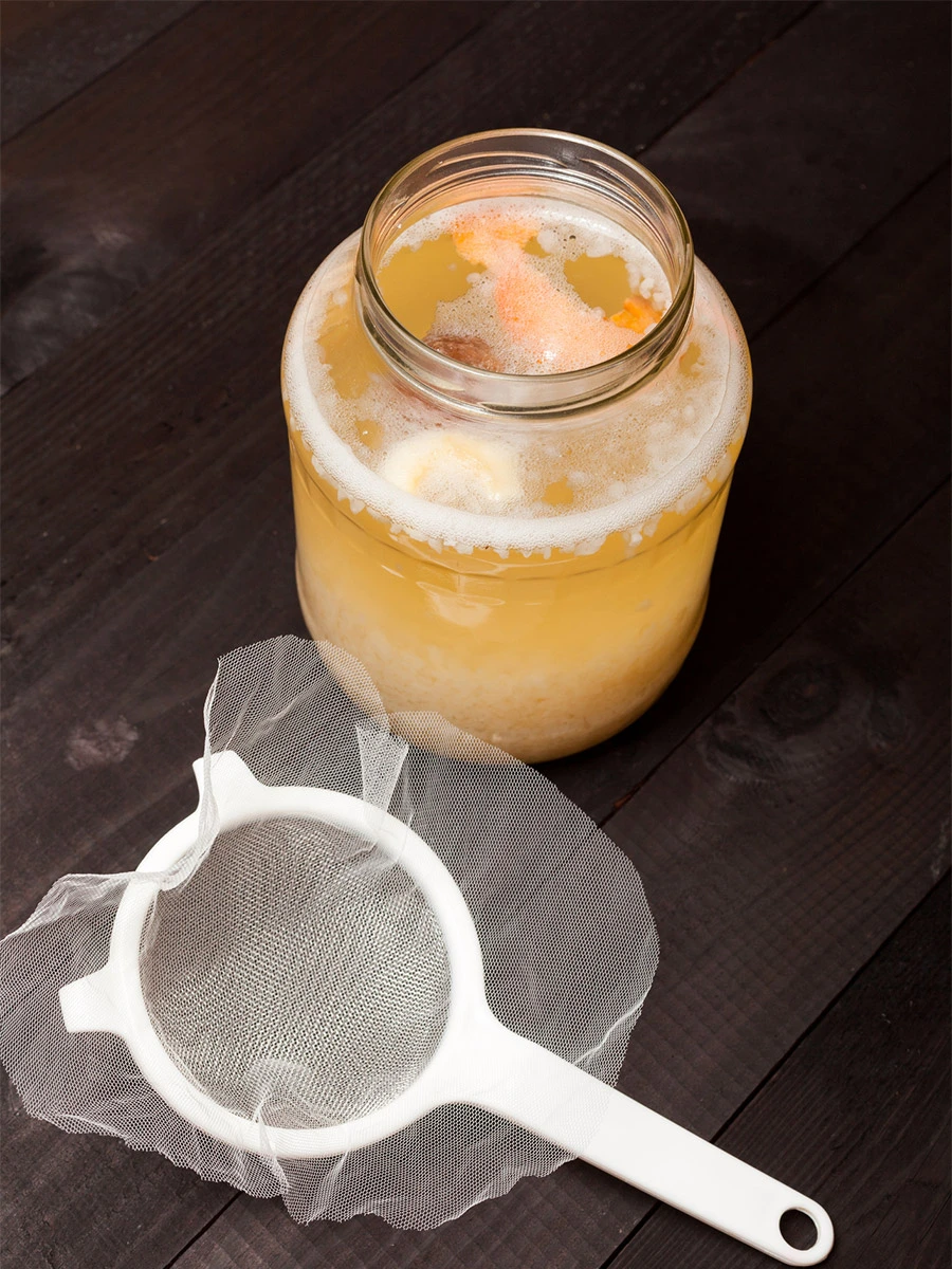 water kefir soda fermenting in jar with fruit flavor