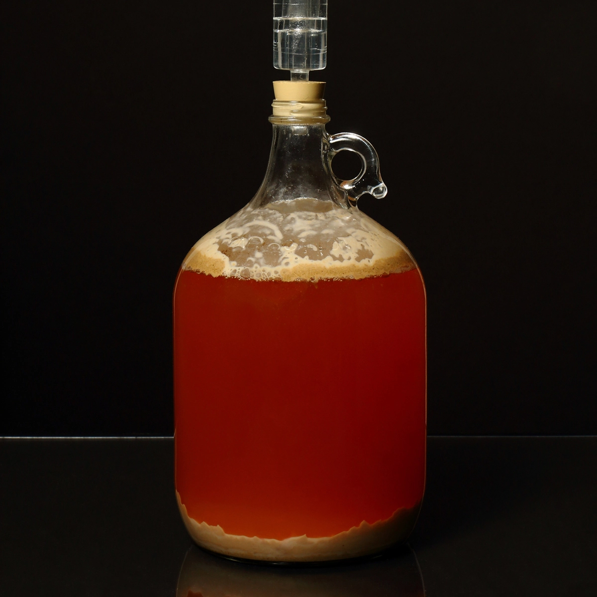 Sediment at the bottom of a carboy full of mead